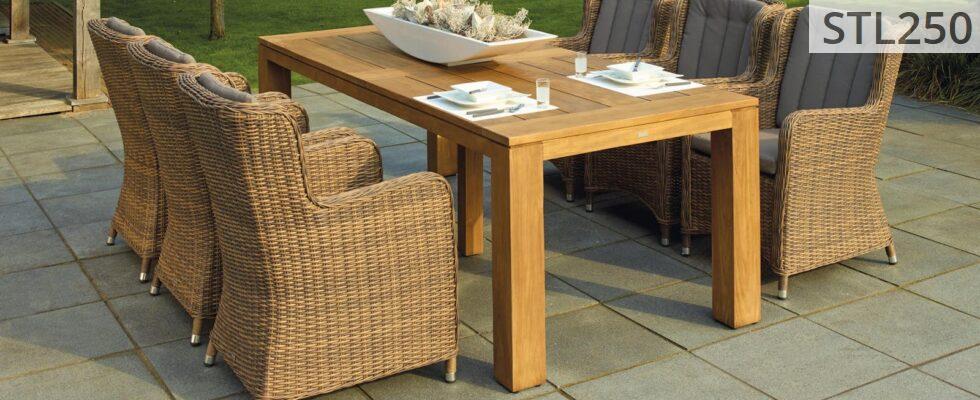 A serene outdoor patio set up with rattan chairs and a wooden table, perfect for relaxation.
