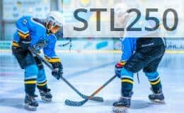 Two young athletes face-off during an ice hockey game in an indoor rink.
