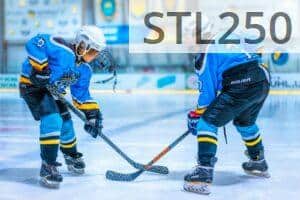 Two young athletes face-off during an ice hockey game in an indoor rink.