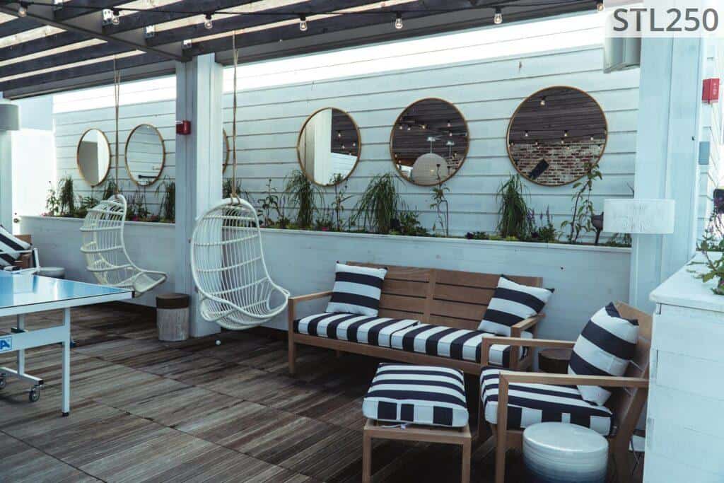 Contemporary outdoor lounge area with stylish furniture and decorative mirrors.