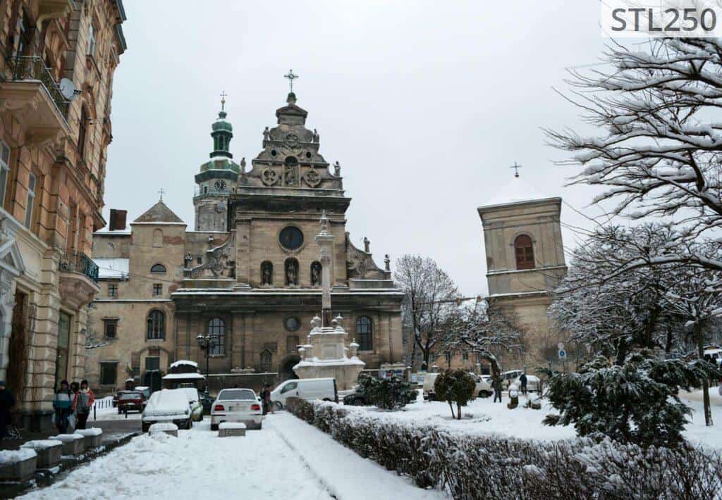 A beautiful winter scene of Lviv with a historic cathedral and snow-covered streets.