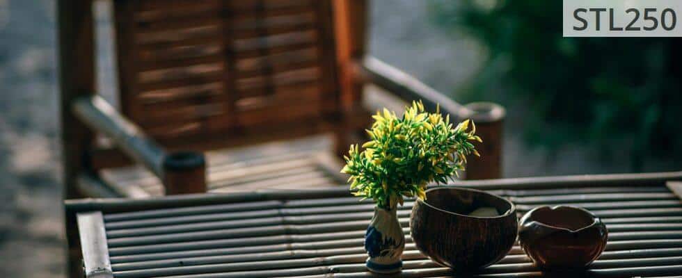 Serene bamboo seating arrangement with vase and greenery in a Thai garden setting.