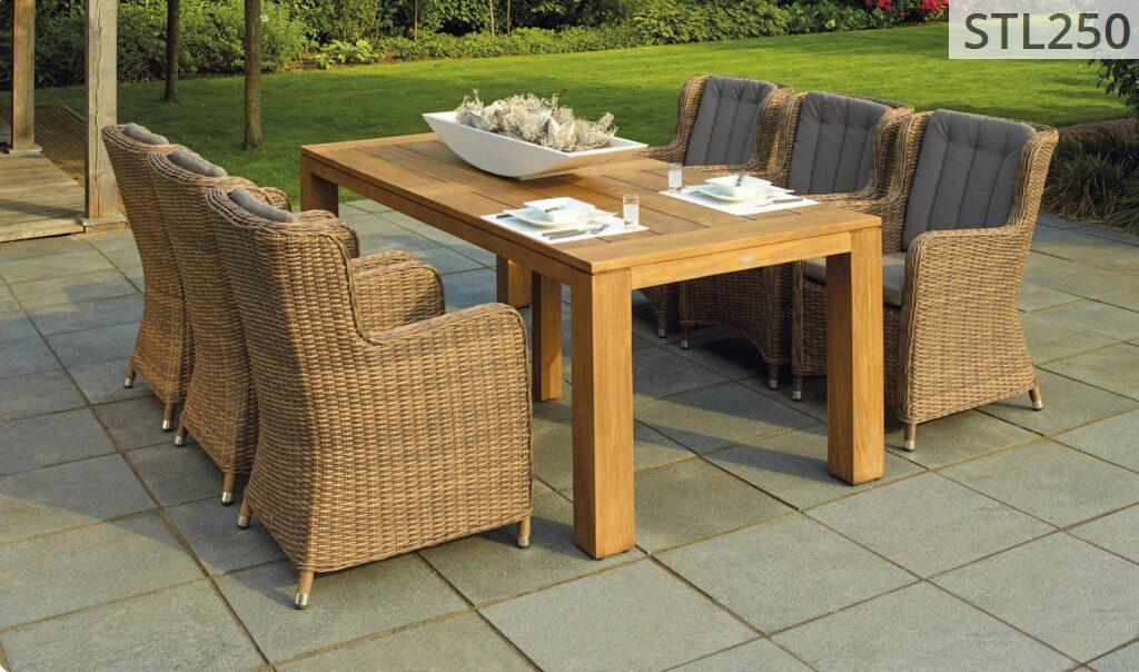 A serene outdoor patio set up with rattan chairs and a wooden table, perfect for relaxation.