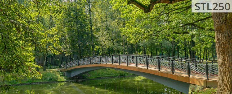 Peaceful park scene featuring a curved bridge over a tranquil river, surrounded by lush greenery.