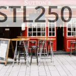 Cozy Irish pub exterior with vibrant red facade and inviting seating. Perfect for urban exploration.