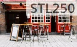 Cozy Irish pub exterior with vibrant red facade and inviting seating. Perfect for urban exploration.
