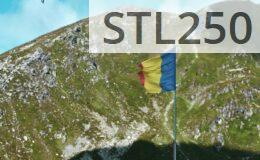 Romanian flag waves atop a scenic mountain landscape under a clear blue sky.