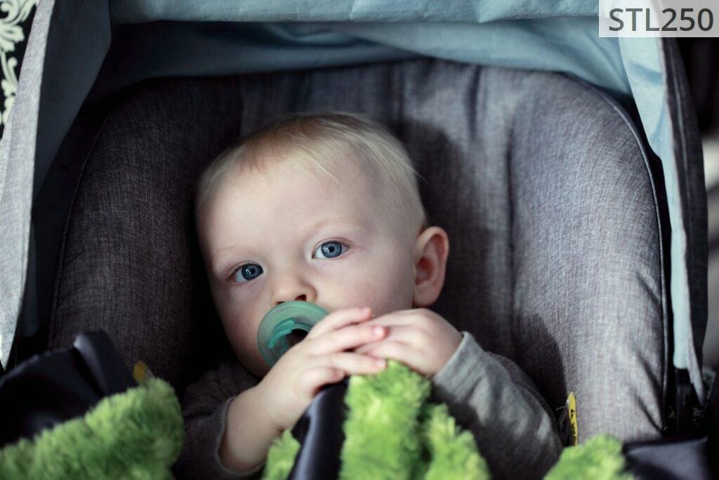 baby on gray stroller