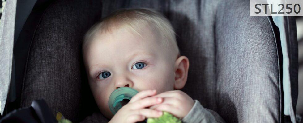 baby on gray stroller