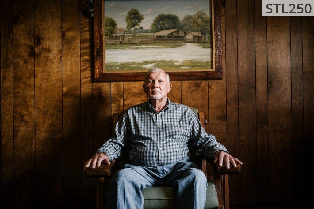man sitting on armchair beside photo frame