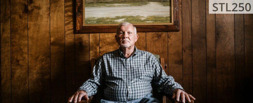 man sitting on armchair beside photo frame